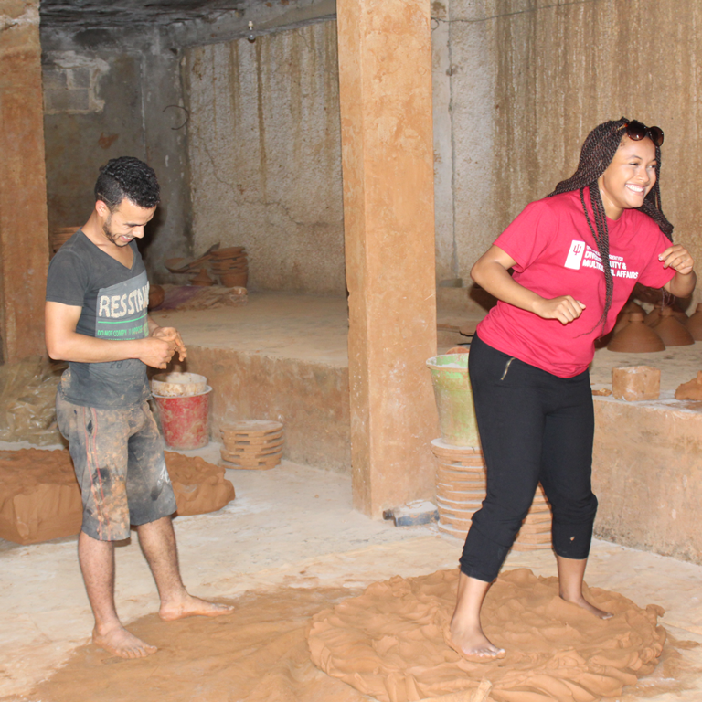 Mica Caine playfully stomps wet clay during her study abroad experience in Morocco. 