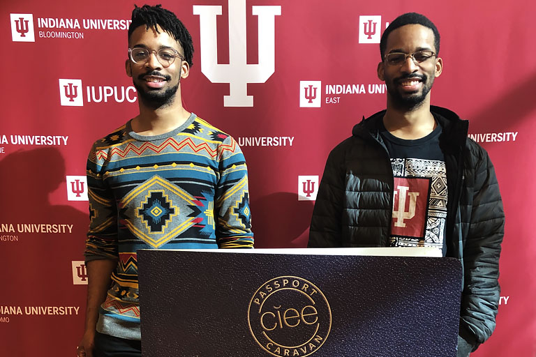 Two students pose with oversized-passport