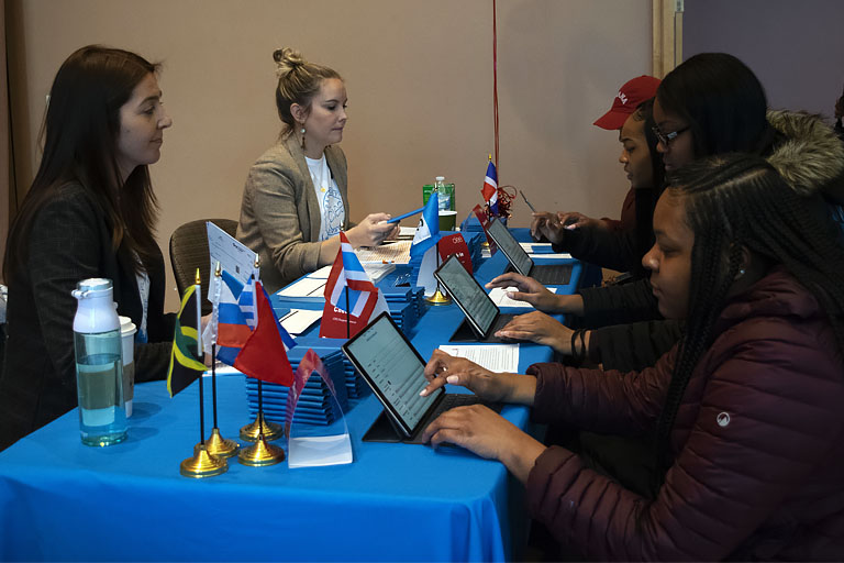 Passport Caravan students fill out digital forms using iPads