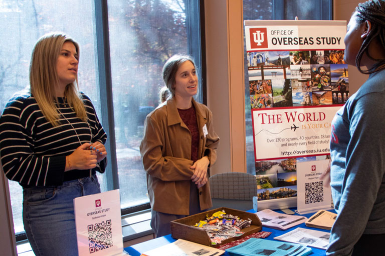 Table attendees speak with a student during the study abroad fair 2022.