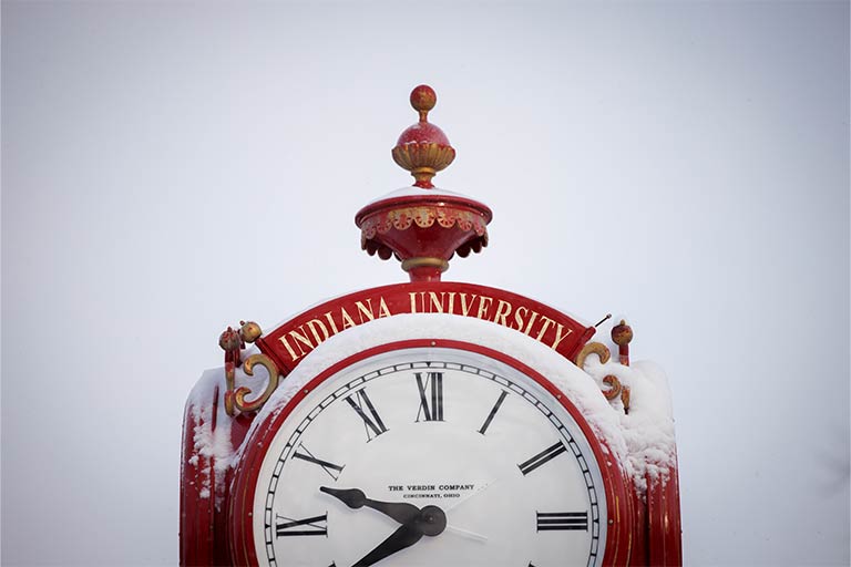 Snow accumulates on a red clock near Woodburn Hall on a winter day at IU Bloomington 