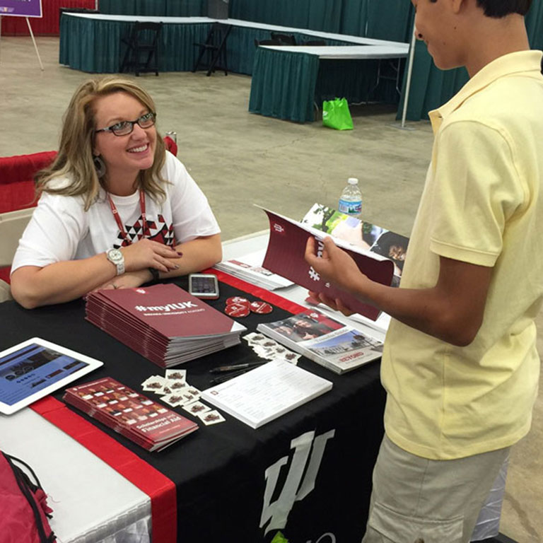 A presenter talks with a participant at a booth at the Indiana Latino Expo.